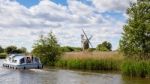 View Of A Boat Passing Turf Fen Mill At Barton Turf Stock Photo