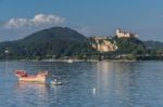 Rowing Boat Pulling A Traditional Boat On Lake Maggiore Piedmont Stock Photo