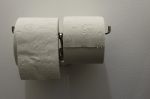 Toilet Paper On Holder On The Wall Stock Photo