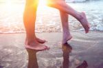 Young Couple Legs On The Beach Sand Stock Photo