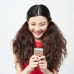 Pretty Amused Girl Reading Funny Sms Stock Photo