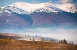 Snow Caped Mountains. Morning Fog In Valley. Misty Hills Stock Photo