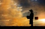 Farmer Walking At Sunset Stock Photo