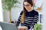 Confident Young Woman Working In Her Office With Laptop Stock Photo