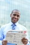 Handsome Male Executive Reading A Newspaper Stock Photo