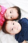 Twin Baby Sisters Lay Down In Bed Stock Photo