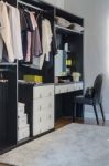 Dark Color Scheme Modern Walk In Closet Design With Black Chair Stock Photo