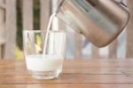 Pour Milk From A Pitcher Into A Glass Stock Photo