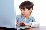 Cute Caucasian Kid Working In Laptop Stock Photo