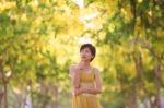 Portrait Of Beautiful Young Asian Woman Thinking Against Yellow Stock Photo