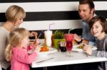 Family Toasting Smoothies In Restaurant Stock Photo