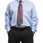 Businessman In Blue Shirt Standing With Hands In Pockets Stock Photo