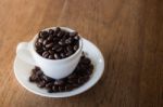 Coffee Cup Or Coffee Beans On Wooden Table Stock Photo
