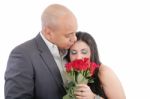 Woman Enjoys The Smell Given Of A Bouquet Of Roses. Happy Couple Stock Photo