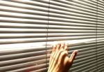 Hand Taking A Peek Through The Window Blinds Stock Photo