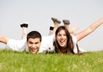 Cute Young Couple Lie Down On Grass Stock Photo