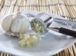 Fresh Garlic Crushed By Garlic Crusher On White Dish On Kitchen Stock Photo