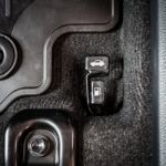 Close Up Hand Switch Of Car Fuel Tank And Hood. Car Interior Stock Photo