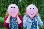 Two Girls Holding Balloons With Facial Expressions Stock Photo