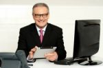 Aged Businessman In Glasses Using Tablet Stock Photo
