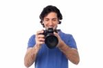 Man Looking At Pictures Stored In Camera Stock Photo