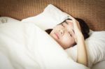 Young Woman Lying In Bed And Having Migraine Stock Photo