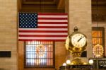 Old Clock And Us Flag At Grand Central Terminal Stock Photo