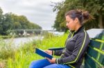 Dutch Woman On Bench At Water Reading Book Stock Photo