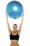 Fit Young Lady Holding Up Big Blue Pilates Ball Stock Photo