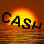 Cash Text Sinking In Sea Stock Photo