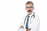 Senior Male Doctor With Crossed Arms Stock Photo