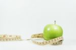 Measuring Tape Wrapped Around A Green Apple. Concept Of Diet Stock Photo