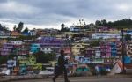 Man Walking In Front Of A Tightly Packed Colorful Village In Ind Stock Photo