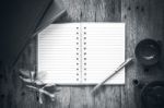 Open Notebook And Pen On Old Wooden Background, Black And White Stock Photo