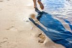 Footprints In The Wet Sand Of The Beach Stock Photo