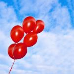 Red Inflatable Balloons On The Sky Background Stock Photo