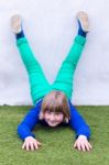 Young Girl Lying Upside Down Against Wall Stock Photo