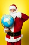 Father Christmas Showing His Country On Globe Stock Photo