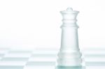 Glass Chess Queen Is Standing On Board, Cut Out From White Backg Stock Photo
