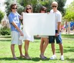 Teens With White Billboard Standing In Park Stock Photo