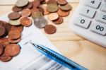 Bill With Coins And Pen And Calculator On Table Stock Photo