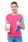 Young Woman Holding Notebook And Beverage Cup Stock Photo