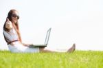 Young Female Sit In The Park And Using A Laptop Stock Photo