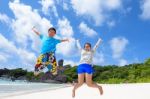 Father And Daughter Jumping On Beach At Thailand Stock Photo