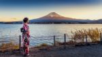 Asian Woman Wearing Japanese Traditional Kimono At Fuji Mountain. Sunset At Kawaguchiko Lake In Japan Stock Photo