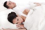 Couple In Bed, Men Sleeping And Woman Lying Disappointed Stock Photo