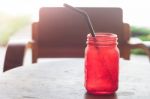 Iced Drink In Red Glass On Wooden Table Stock Photo