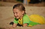Young Girl Playing In The Sand Stock Photo