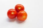 Three Red  Tomatoes On A White  Stock Photo