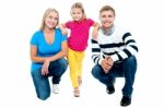 Trendy Couple Squatting With Girl Child In Between Stock Photo